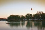 Hot air balloon drifting over the Murray River with Buronga Caravan Park in the background, Mildura, Victoria, Buronga, New South Wales