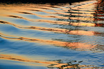 Golden sunset reflection from houseboat wake, Victoria